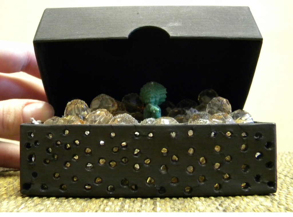 Boxed, custom for exhibition 'Boxed In and Out,' provided found box, found beads and plastic toy, collected dust; 2010